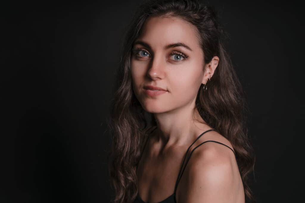Portraitbild einer jungen Frau mit dunklen Haaren und blauen Augen. - Studiolicht Vorteile